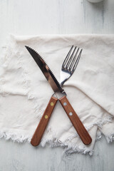 Fork and knive on a white background over a white cloth napkin