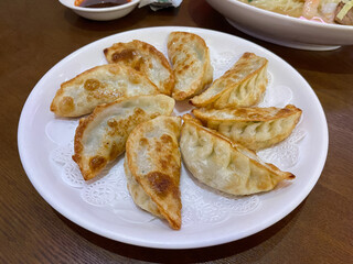 
Fried dumplings on white plate, close-up