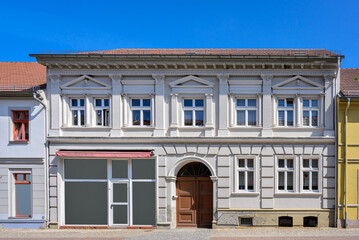 Fototapeta na wymiar Haus mit klassizistischer Schmuckfassade in der Altstadt von Gransee - Fensterscheiben und Graffiti-Schmierereien wurden retuschiert