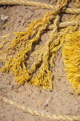 Polluted beach filled with plastic bottles fishing nets, slippers, bottlecaps and various other plastic junk with ocean waves in the background.