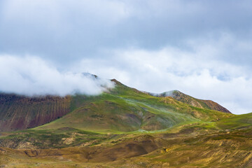 Dark Dramatic Desert Landscape with Foggy Mountains and Distant Houses in Muktinath, Mustang, Nepal