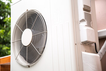 Air compressor external split wall type of outdoor home air conditioner unit installed on outside building. Concepts of cool or heat or hot and air conditioning system maintenance service cleaning.