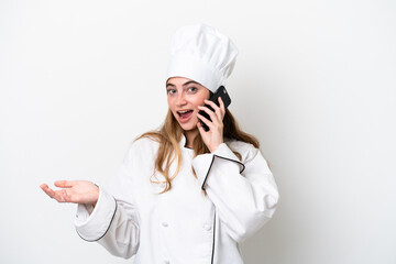 Young caucasian chef woman isolated on white background keeping a conversation with the mobile phone with someone