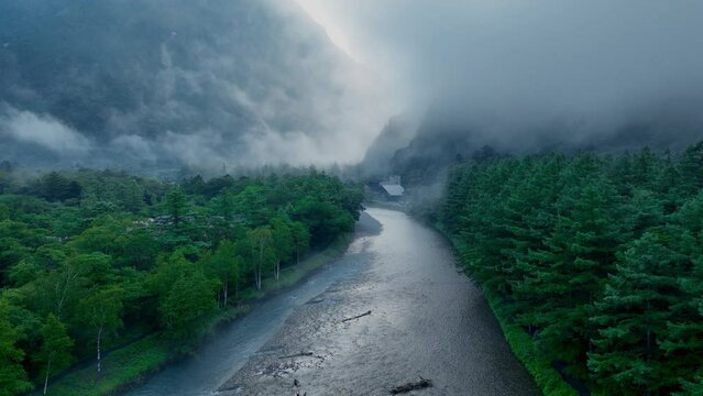 Atmospheric Halloween landscape, foggy morning river in the mountain valley, Kamikochi valley, hiking in Japanese Alps