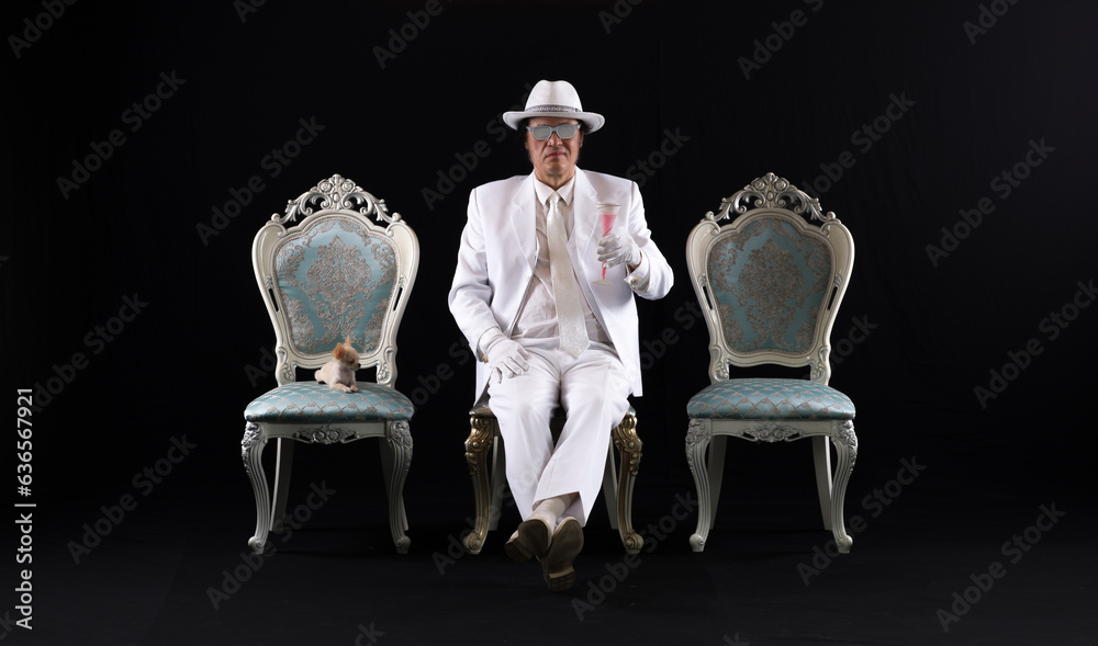 Sticker rich gentleman in a white suit sits on a chair, black studio background