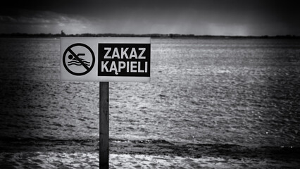 SAFETY ON THE WATER - Warning sign on the shore of the lake with the words "NO SWIMMING"
