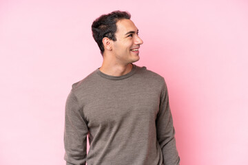 Young caucasian man isolated on pink background thinking an idea while looking up