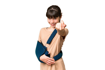 Little caucasian girl with broken arm and wearing a sling over isolated background doing coming...