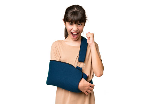Little caucasian girl with broken arm and wearing a sling over isolated background celebrating a victory in winner position