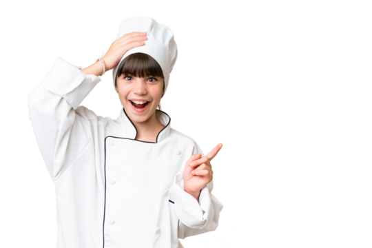 Little caucasian chef girl over isolated background surprised and pointing finger to the side