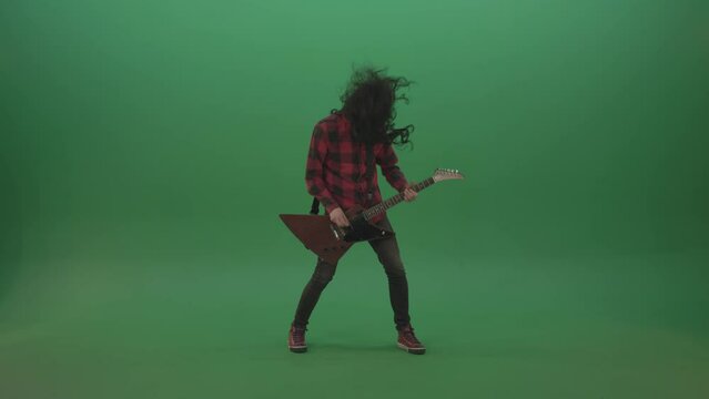 Long black hair hardcore rock man guitarist play guitar and shaking head isolated on green screen