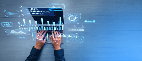 Man hands typing on laptop with digital business dashboard, top view