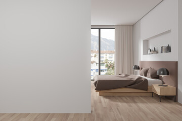 Stylish hotel bedroom interior with bed and panoramic window. Mock up wall