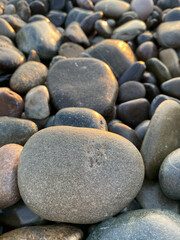 sea ​​stones pebbles lighting before sunset top view vertical photo