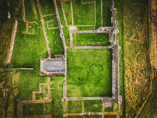 Aeriel drone view of an old castle ruins in england, countryside and grass fields