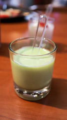 Matcha tea green jelly pudding dessert in a small glass.