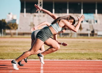 Fotobehang Extreme Sporten Action, sports and athlete running sprint in competition or fitness game or training for energy wellness on track. Race, stadium and athletic people or runner exercise, speed and workout performance  © Mumtaaz D/peopleimages.com