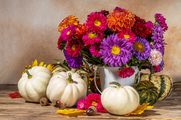 Flowers and pumpkins on table