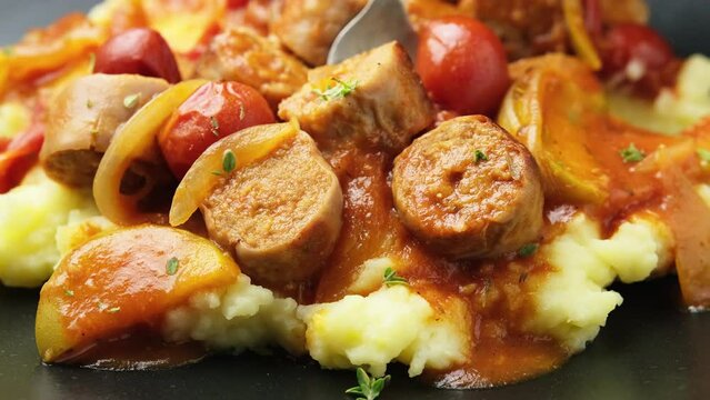 Eating with fork, Devilled Sausages with mashed potato, spiced tomato and apple sauce.