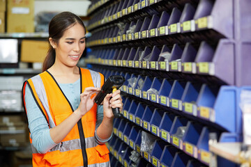 factory worker using laser barcode scanner and looking spare parts storage cabinet