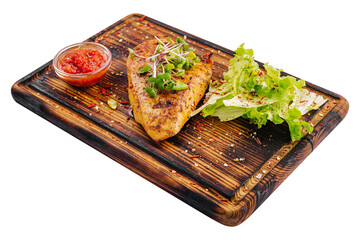 chicken breast with spicy sauce on wooden board