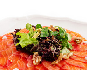 Salmon carpaccio with salad on plate