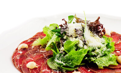 Veal carpaccio with parmesan cheese on white plate
