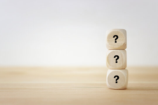 Wooden cubes with question marks on a white background