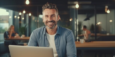 Fototapeta premium Businessman smiling using laptop computer sitting at worktable at modern office. Happy man, entrepreneur, small business owner working online, generative ai