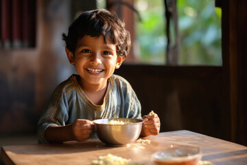 Indian little boy smiling while eating food