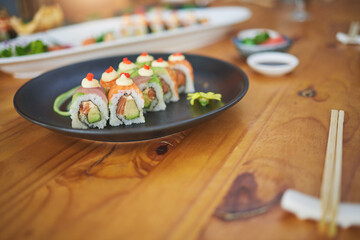 Restaurant, meal and closeup of sushi on a plate for luxury, healthy and authentic Asian cuisine. Platter, fine dining and zoom of a Japanese food for lunch, dinner or supper at a traditional cafe.
