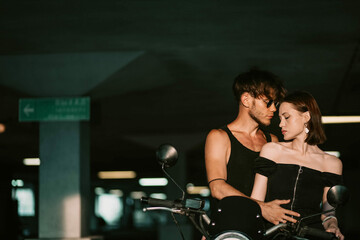 Fototapeta na wymiar fashionable couple motorcyclist and woman near the motorcycle. Motorcycle love.