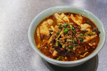 a bowl of Luosifen(Snail rice noodle) on table. Smelly Chinese noodle soup from Liuzhou, Guangxi