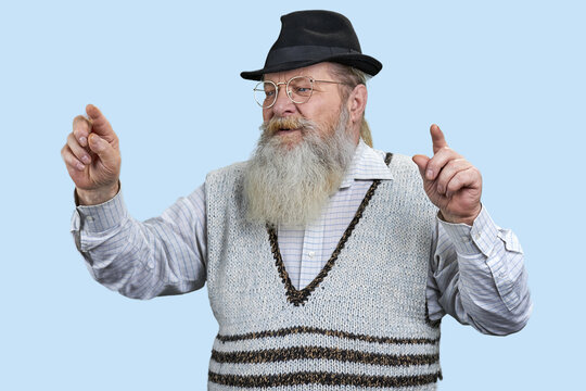 Portrait of bearded old man touching an imaginary screen with his fingers. Isolated on blue.