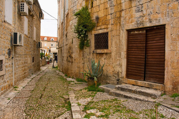 Fototapeta na wymiar A street in Supetar on Brac Island, Croatia, with traditional kogule or kogulavanje paving. Common in coastal villages throughout Dalmatia, it uses pebbles from beach
