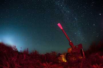 Star tracks, gun on the hill. The night sky on long exposure. Landscape of the night sky