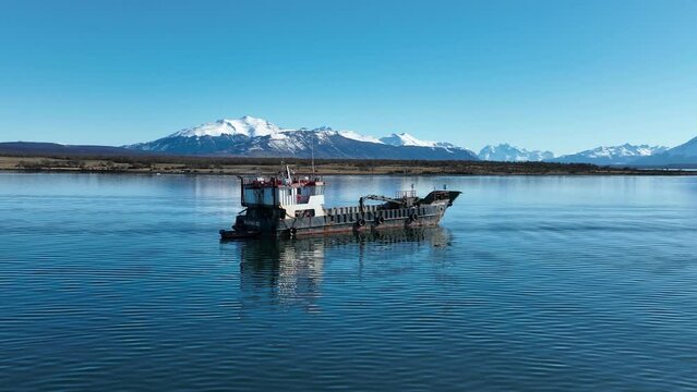 Moored Boat At Puerto Natales In Ultima Esperanza Chile. Snowy Mountains. Bay Water Landscape. Ultima Esperanza Chile. River Background. Moored Boat At Puerto Natales In Ultima Esperanza Chile.