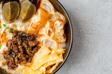 Rice porridge or congee with minced pork, century egg and cakwe in bowl