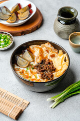 Rice porridge or congee with minced pork, century egg and cakwe in bowl