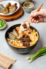 Rice porridge or congee with minced pork, century egg and cakwe in bowl