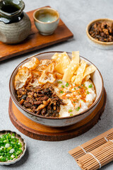 Rice porridge or congee with minced pork, century egg and cakwe in bowl