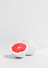 Creative fruit concept. White cut orange on white background with copy space.