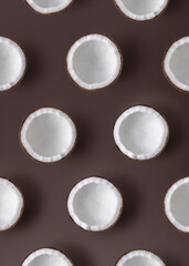 Pattern of coconut halves on brown background. Top view.