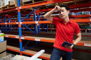 worker feeling tired and have a headache from work in the warehouse storage
