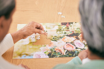 Puzzle on table, entertainment and senior couple in home for bonding, fun activity and relax together. Retirement, marriage and above of man and woman with jigsaw for playing games, hobby and connect