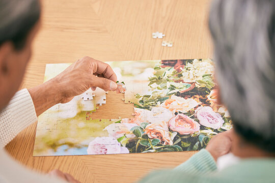 Puzzle on table, entertainment and senior couple in home for bonding, fun activity and relax together. Retirement, marriage and above of man and woman with jigsaw for playing games, hobby and connect - Powered by Adobe