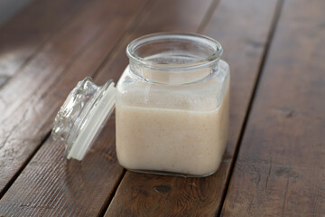 shio koji sauce in a glass bottle on top of wooden table with wooden spoon
