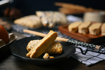 Sliced raw Tempeh on black plate. Tempeh or Tempe made from fermented soybeans, vegetarian food