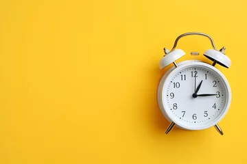 Fotobehang Alarm clock on a plain yellow background © Tarun