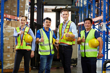group of workers thumbs up pose after success work in the warehouse storage